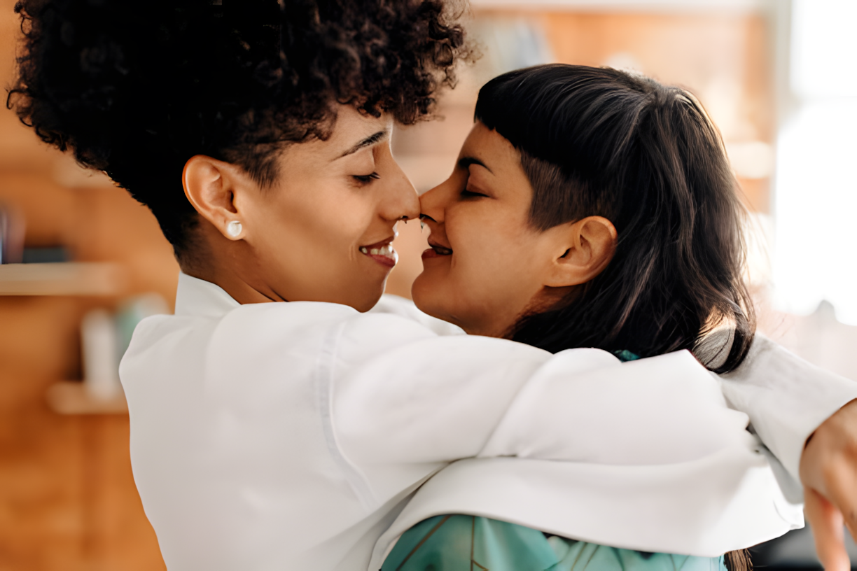 Couple lesbien tenant la main, soutenu par une doula, exprimant leur désir d'avoir un enfant.